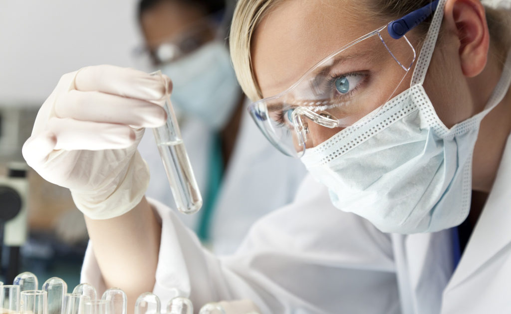 Female Scientific Research Team With Clear Solution In Laborator